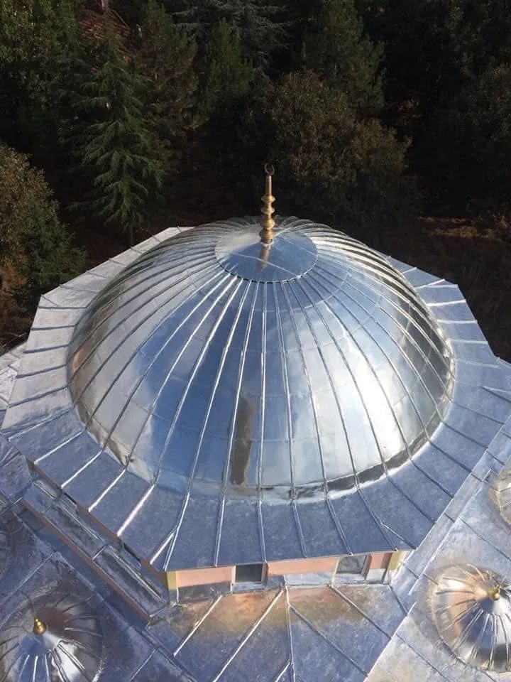 Alüminyum kaplı camii kubbesi ve altın alem — havadan çekim